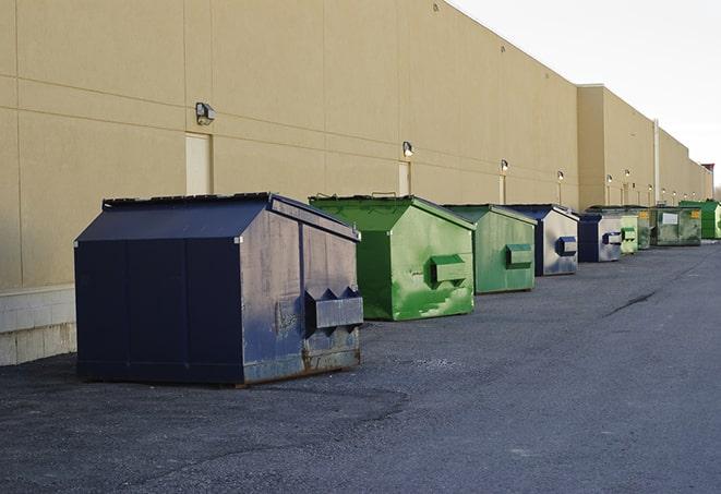 a group of construction workers taking a break near a dumpster in Greenback